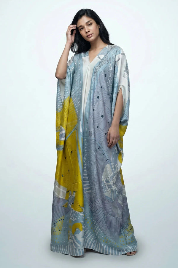 Blue boho beach kaftan with model adjusting hair showing fluid silk maxi