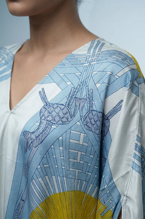 Close-up of blue silk kaftan V-neckline and abstract woven print detail