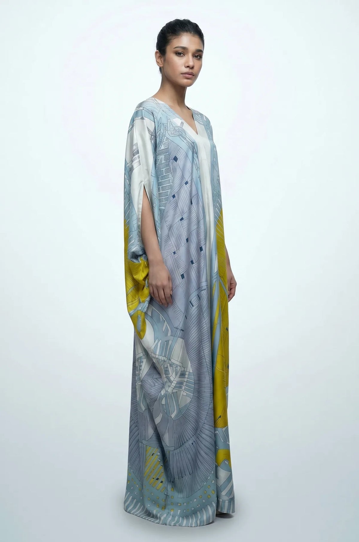 Side profile of blue Lupis kaftan showing flowing silk-touch drape