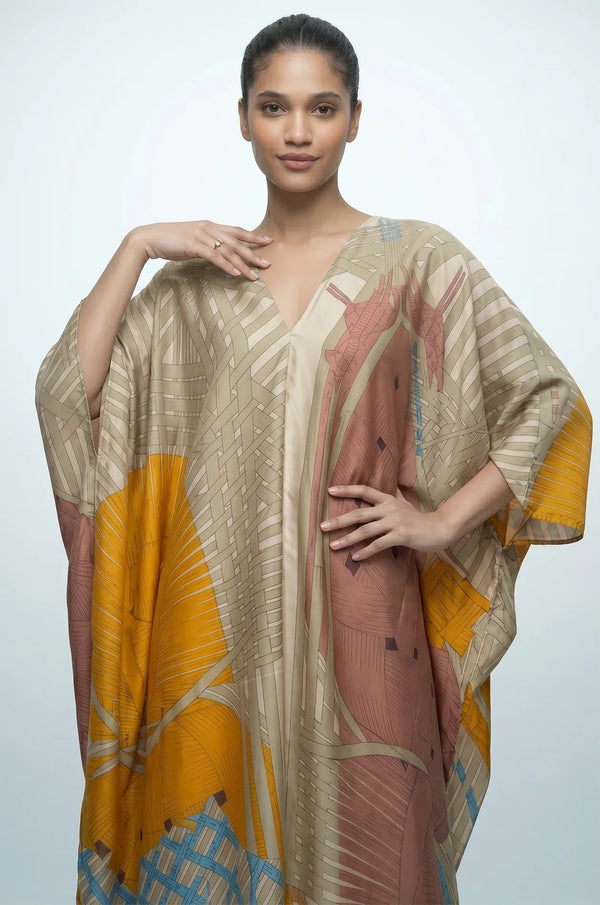Woman wearing sage green Lupis silk kaftan front detail with V-neckline and woven print