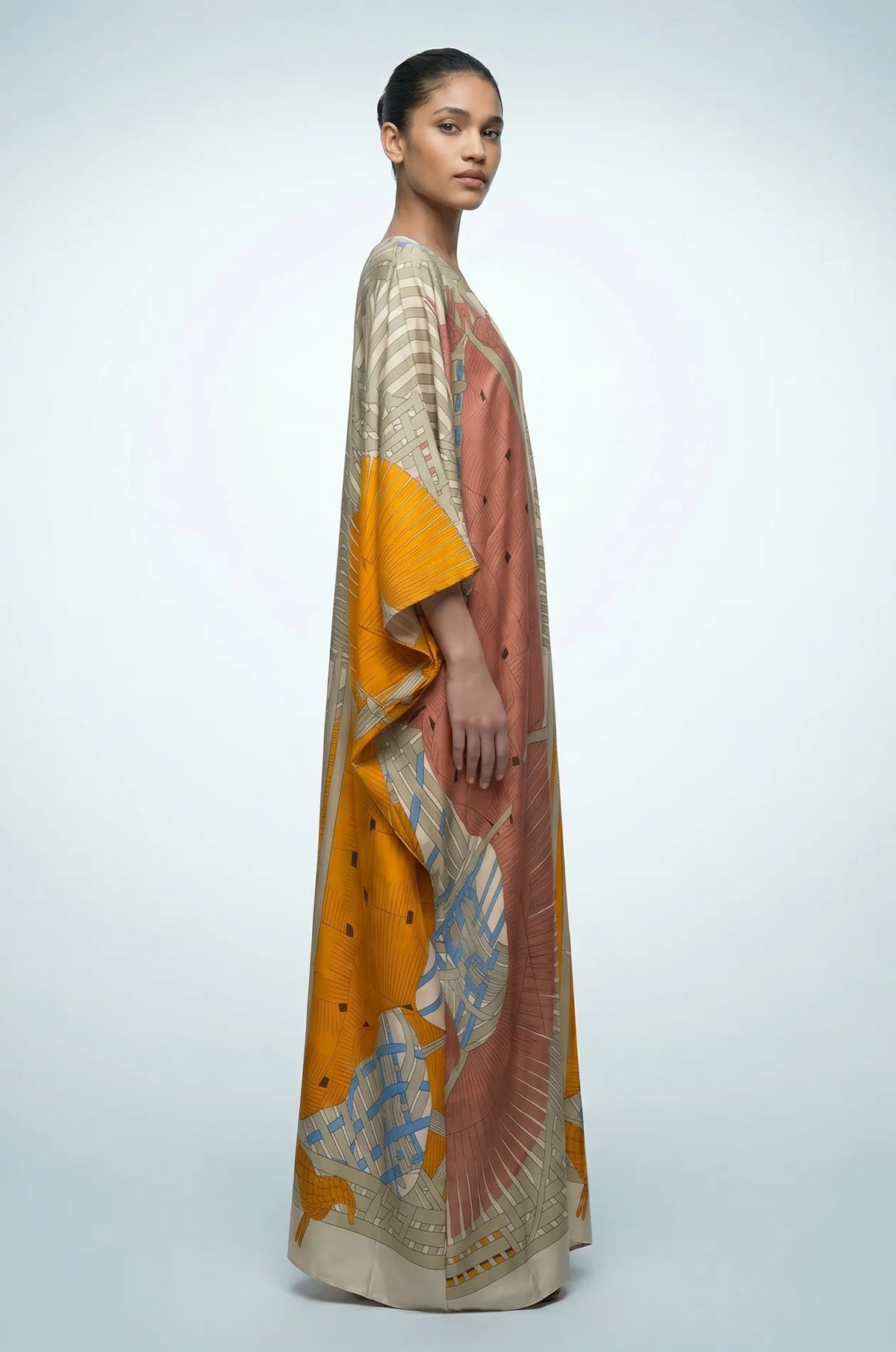Side profile of green Lupis kaftan showing flowing silk-touch drape