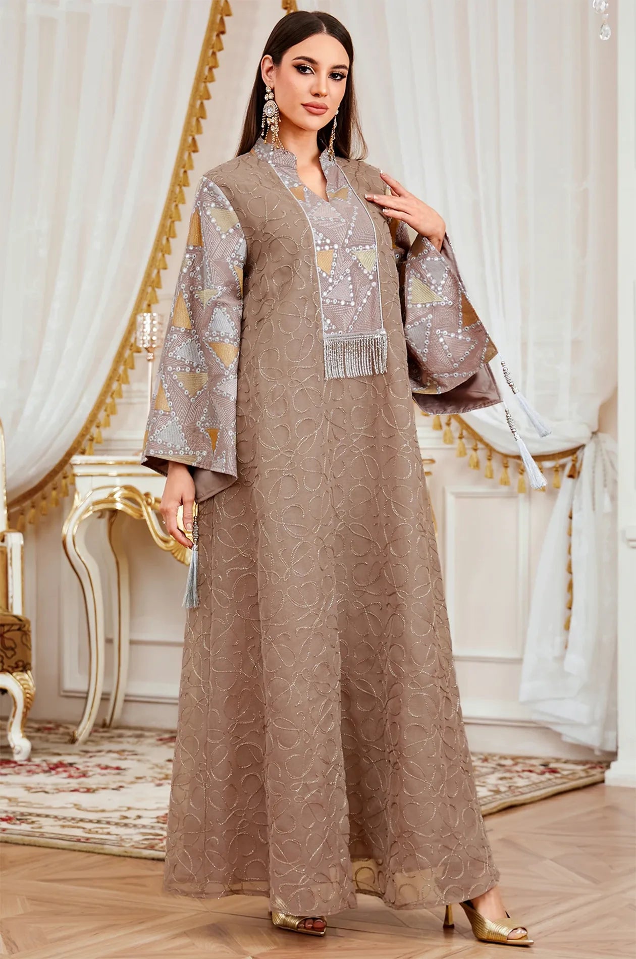 Fashion shot of the Brown Kaliera embellished kaftan, displaying the warm taupe fabric and contrasting geometric paneling.