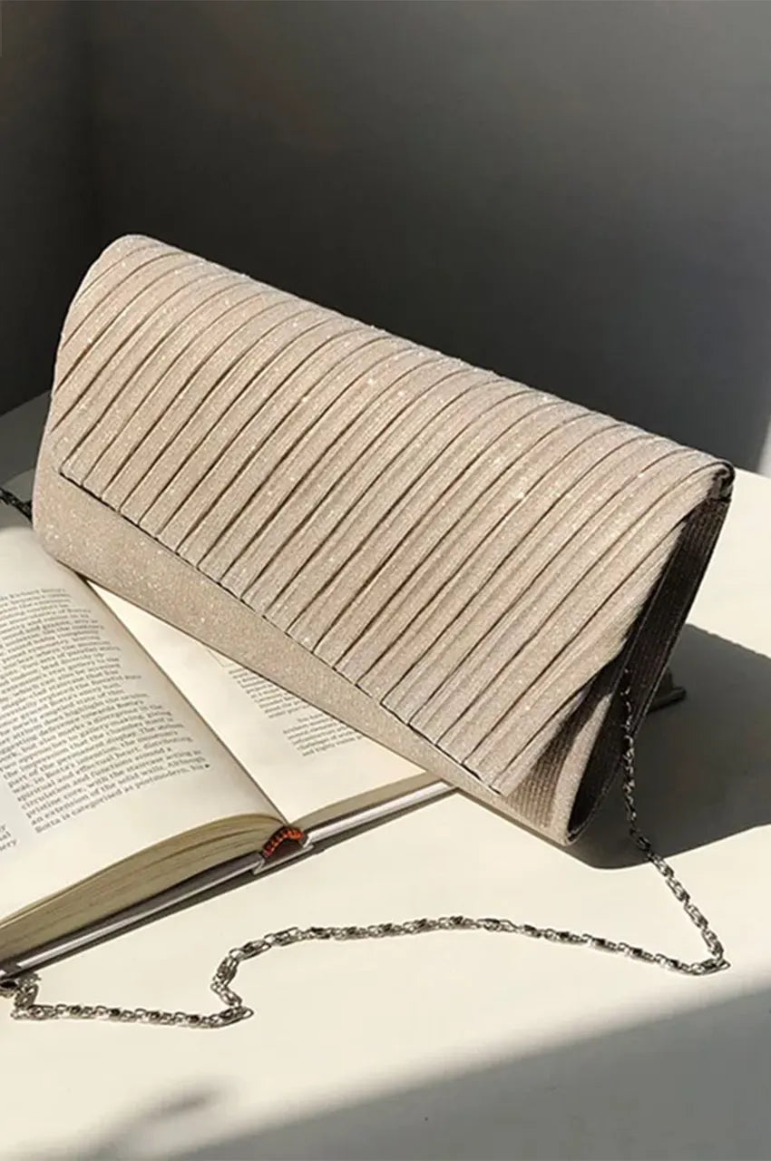 Angled profile view of the champagne gold glitter envelope clutch showcasing the structured pleated design and elegant silhouette.