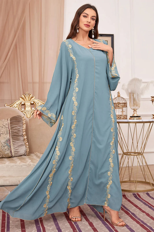 Elegant movement and draping of the long blue Tahra kaftan.