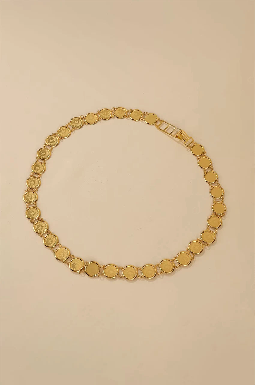 Artistic circle layout of the gold lira coin belt on a beige background.