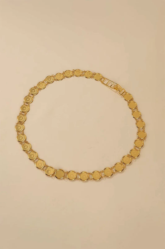 Artistic circle layout of the gold lira coin belt on a beige background.