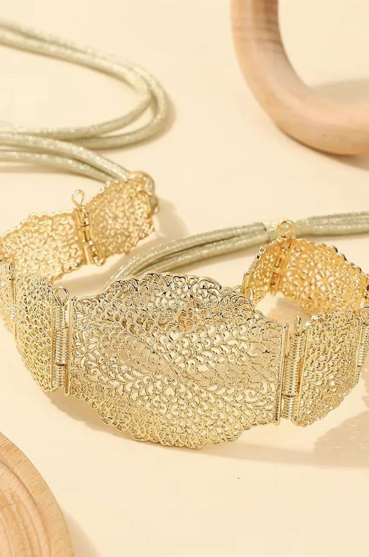 Gold metal belt curved to show flexibility of the hinged filigree plates.