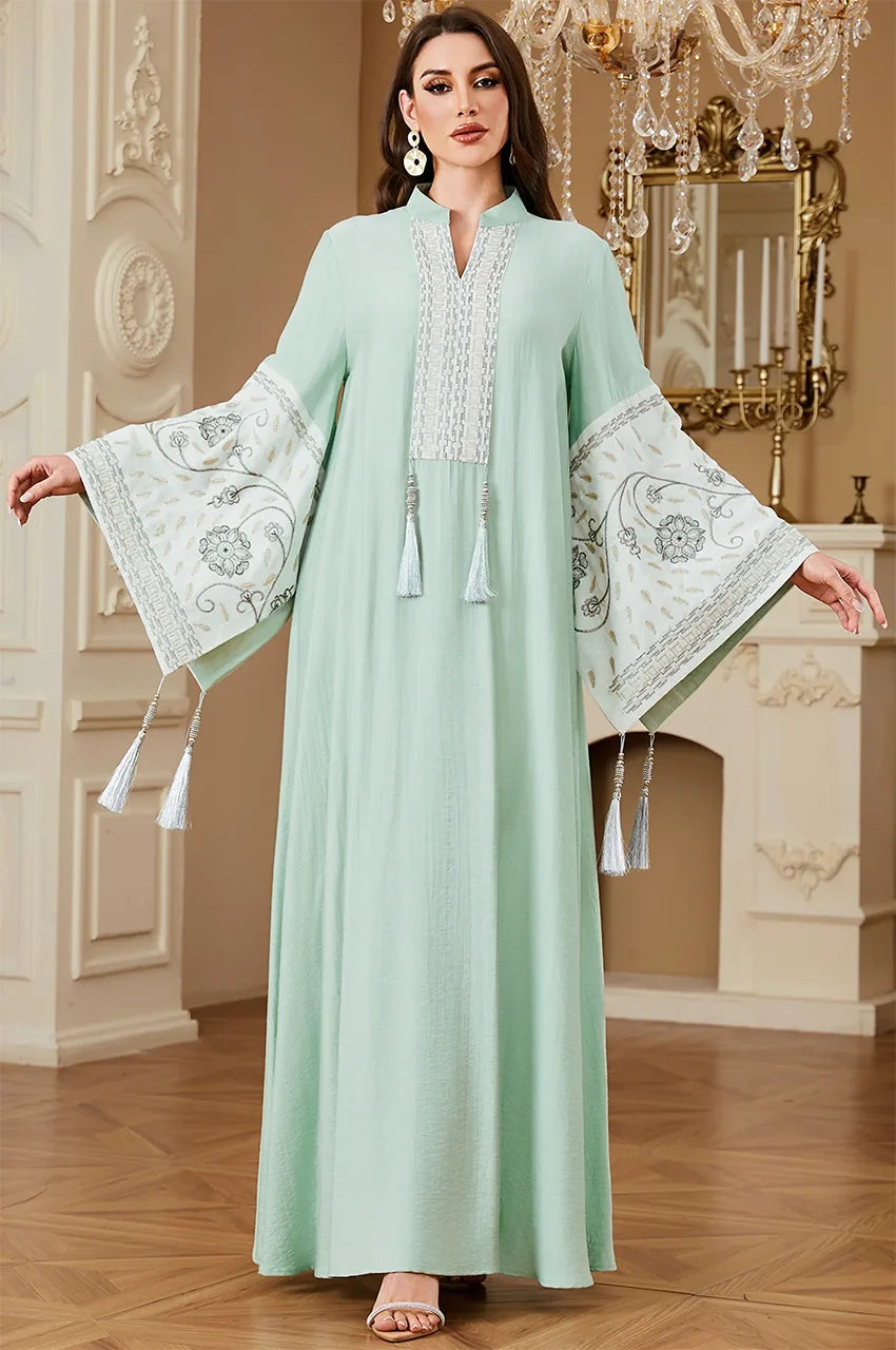 The Cyan Nairi cotton kaftan maxi with arms extended to display the full width and embroidery of the traditional bell sleeves