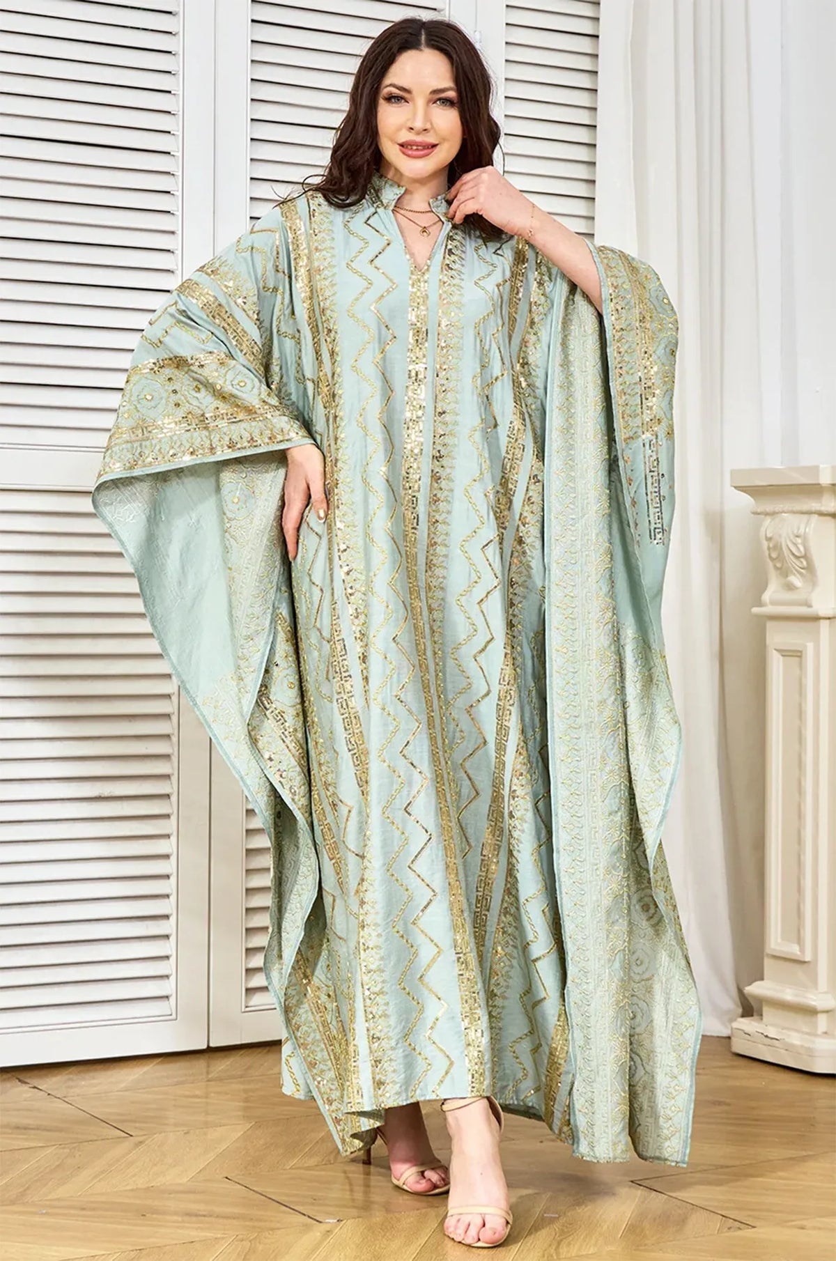 Model showcasing the light green butterfly batwing sleeves of the Delphin kaftan.