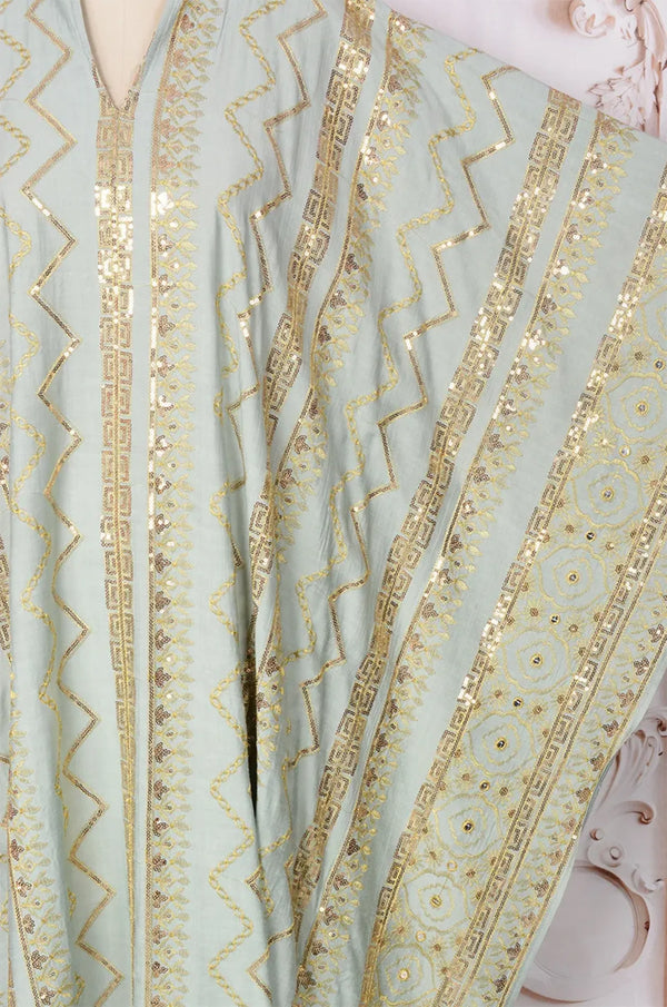 Close-up detail of the gold sequin zigzag embroidery on the light green Delphin kaftan.