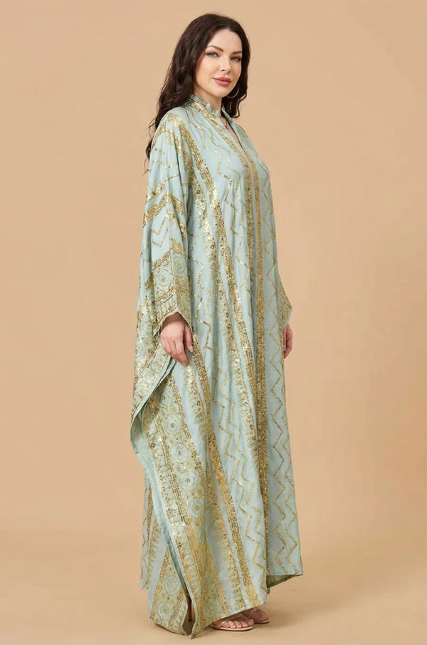 Side profile of the Delphin light green kaftan highlighting the sleeve volume and gold accents.