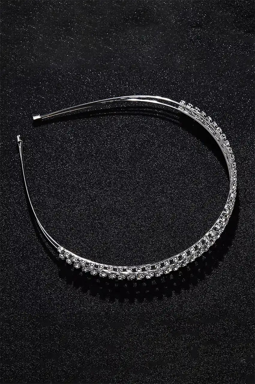 Close-up of double-row rhinestone setting on silver metal headband.