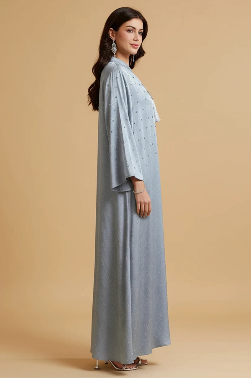 Side profile of woman wearing Elani satin kaftan highlighting sleeve detail and fabric sheen.