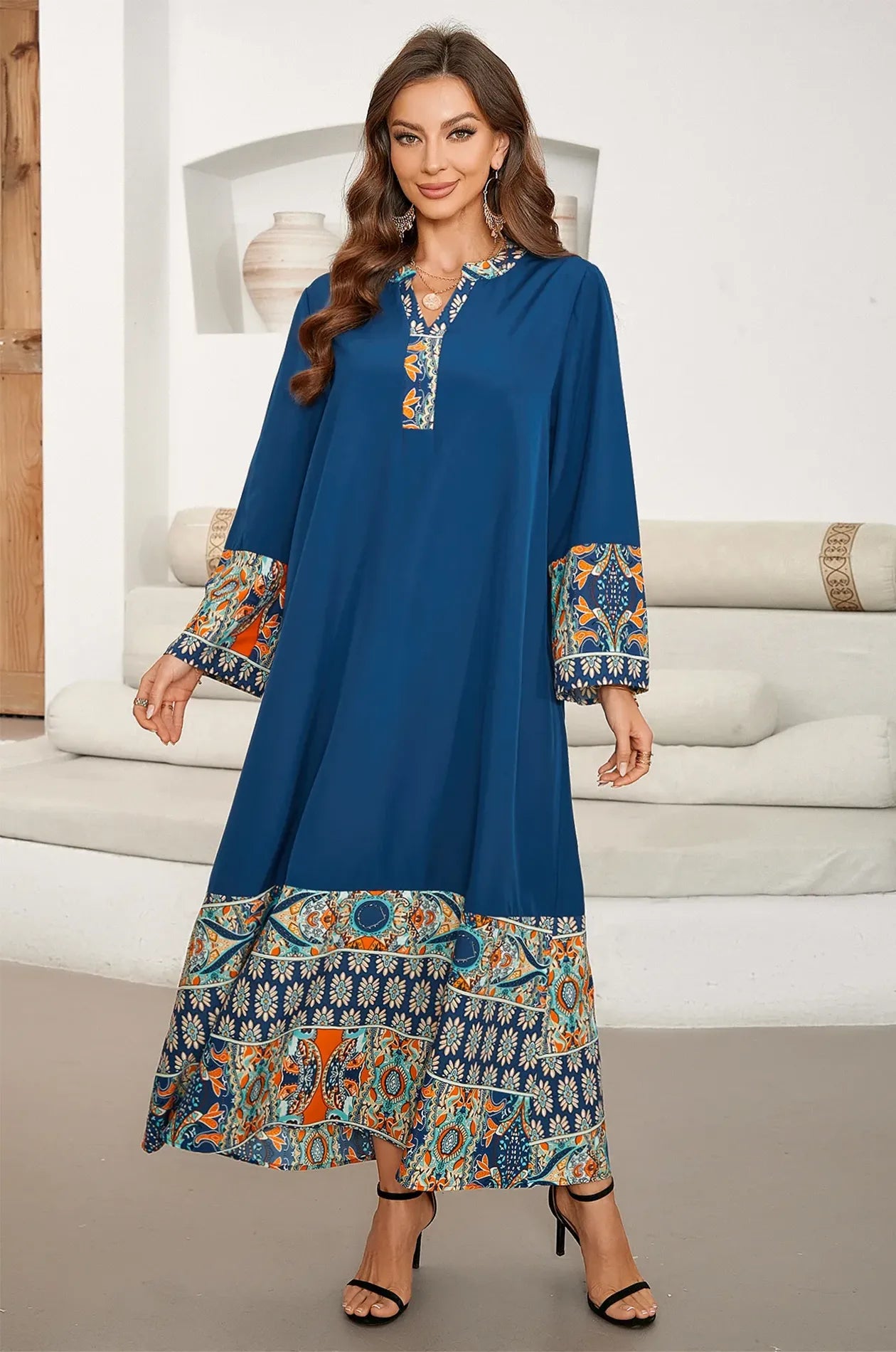 Model wearing Elyah indigo kaftan in a white minimalist architectural setting