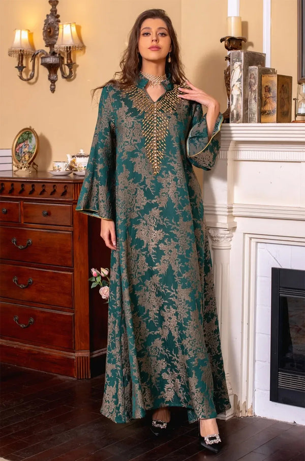 Full-length shot of the model wearing the dark green Estel kaftan with a hand near her shoulder, showcasing the floral gold embroidery.