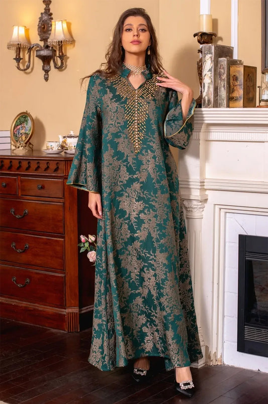 Full-length shot of the model wearing the dark green Estel kaftan with a hand near her shoulder, showcasing the floral gold embroidery.
