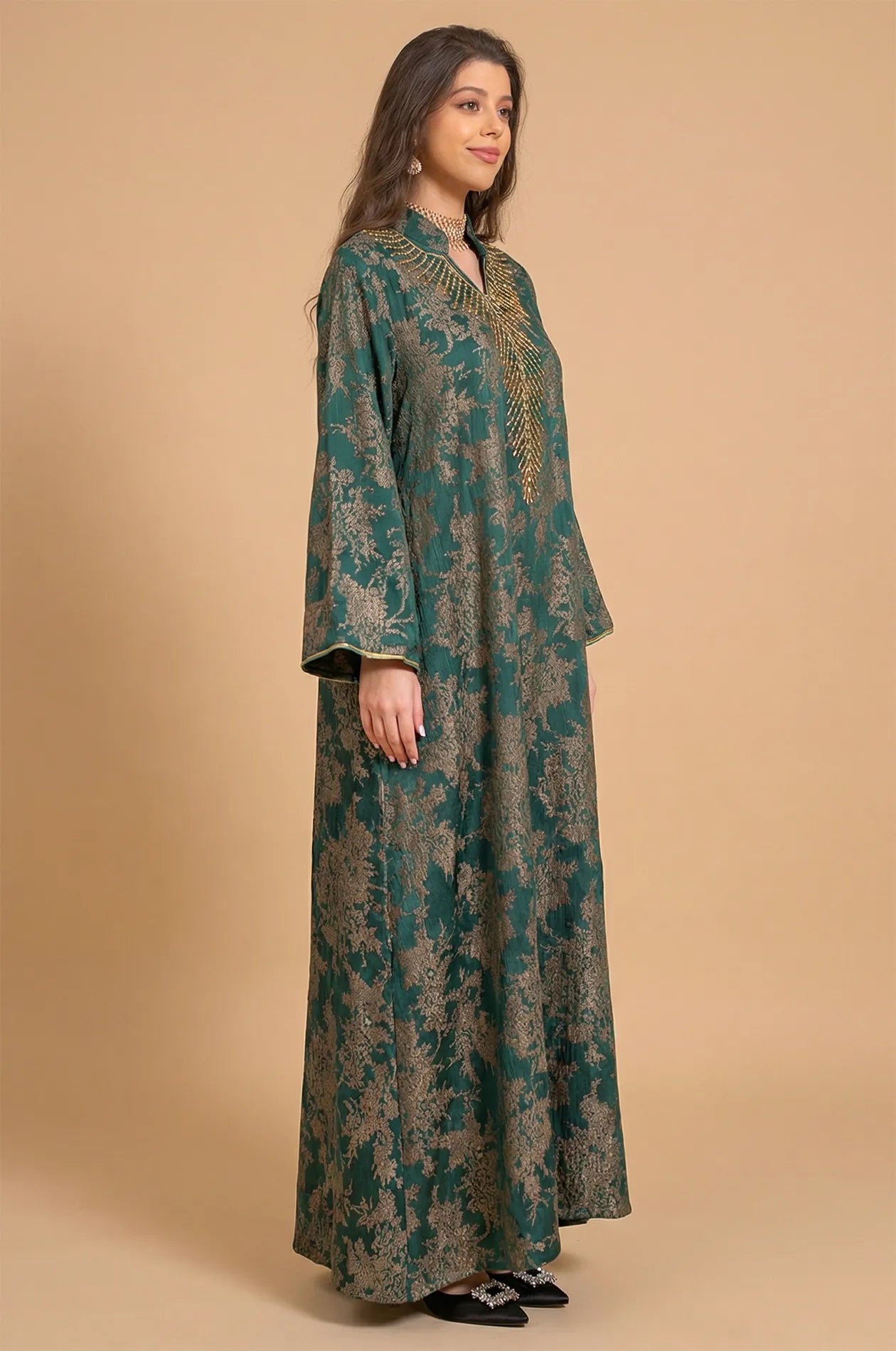 Side three-quarter profile of the Estel dark green kaftan showing the elegant drape and butterfly sleeves in a studio setting.