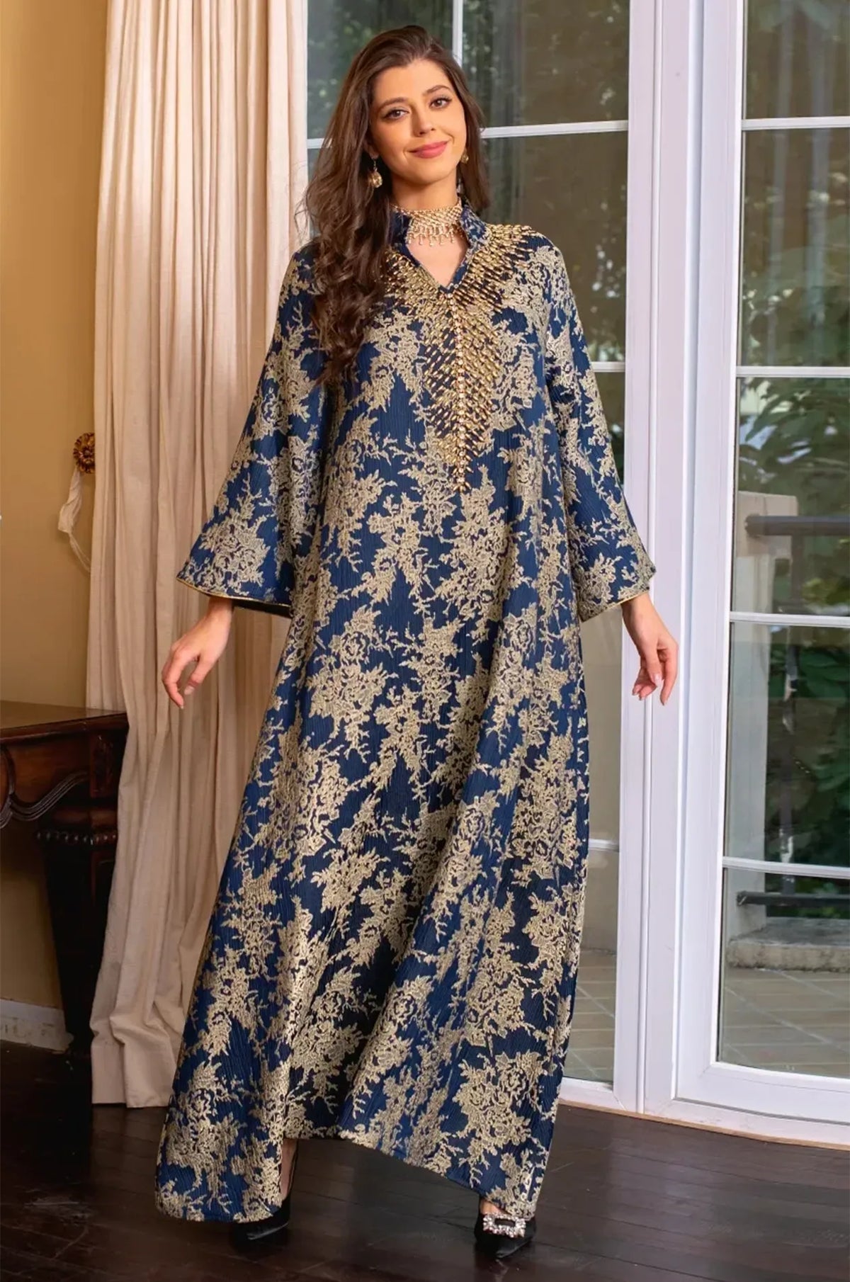 Full-length shot of the model with arms slightly outstretched to showcase the full span of the butterfly sleeves on the Estel kaftan.