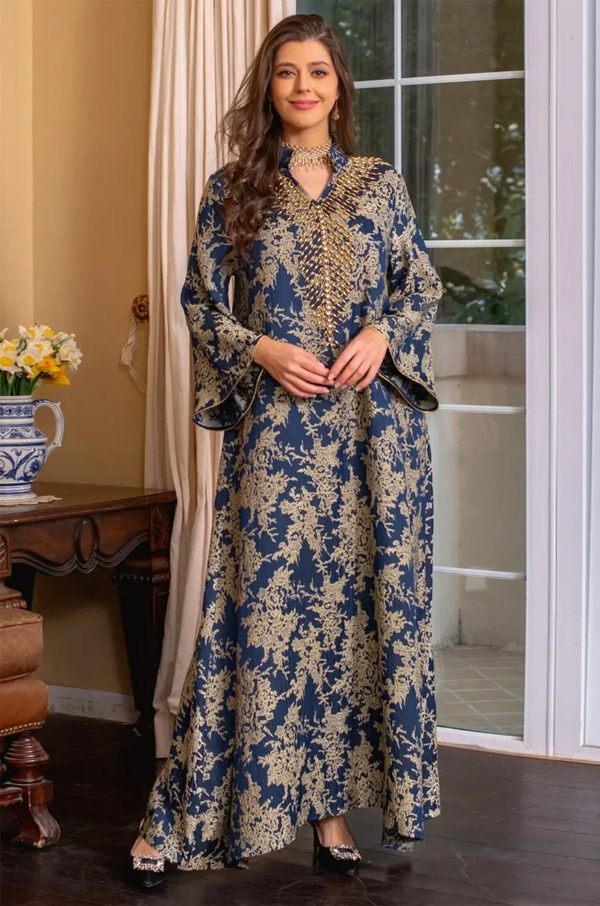 Full-body shot of the model walking in the navy blue Estel kaftan, highlighting the movement of the butterfly sleeves.