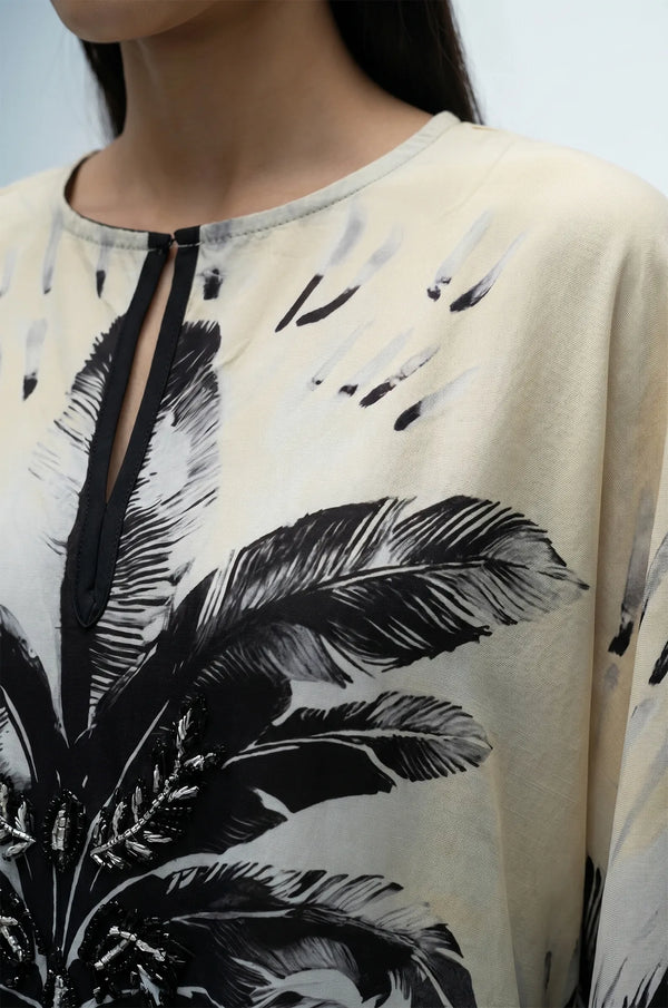 Close-up of flamingo kaftan keyhole neckline with hand-beaded palm detail