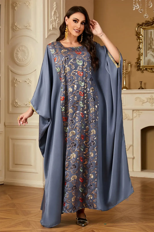 Glamour shot of the gray Amiri farasha kaftan in a luxury interior setting, perfect for formal party inspiration.