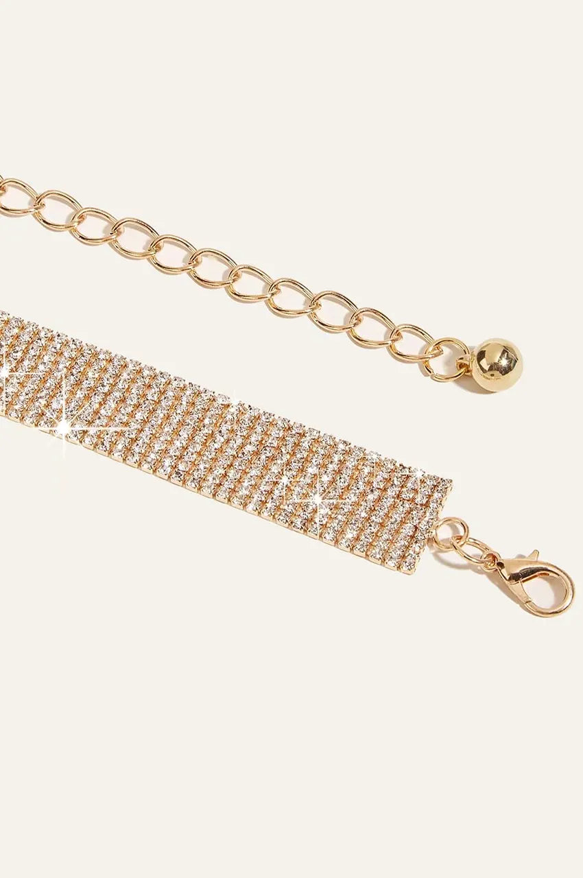 Macro detail of the gold lobster clasp and adjustable chain on the crystal belt.