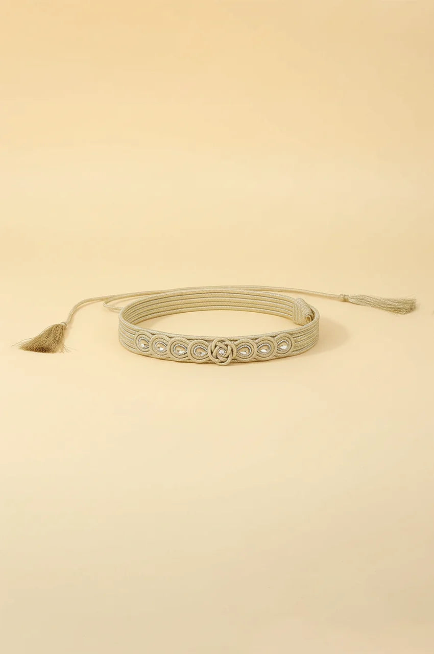 Coiled champagne gold braided waist belt showing flexibility and adjustable rope closure.