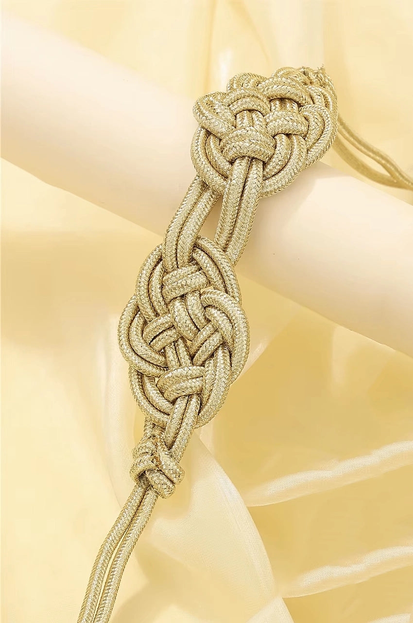 Close-up of double gold Celtic knot centerpiece on braided rope kaftan belt.