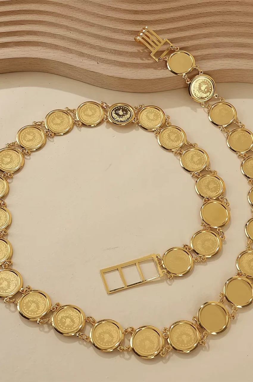 Flat lay display of the gold coin waist chain showing the full length and clasp.