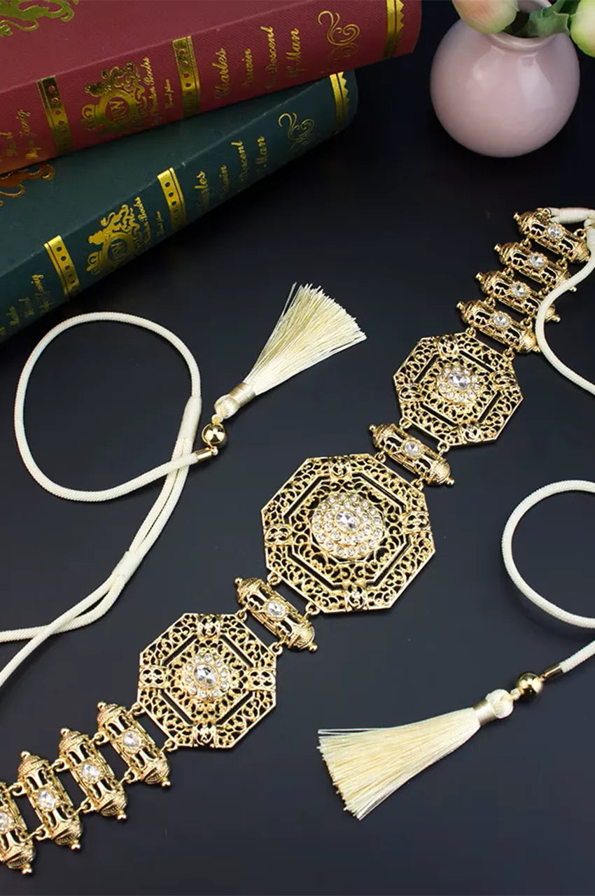 Flat lay display of the full gold geometric belt showing the metal links and cream rope ties.