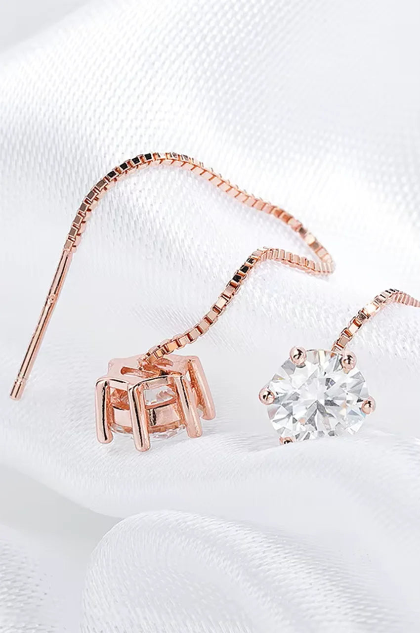 Macro detail of the gold-plated prong setting holding a VVS1 moissanite stone attached to a box chain.