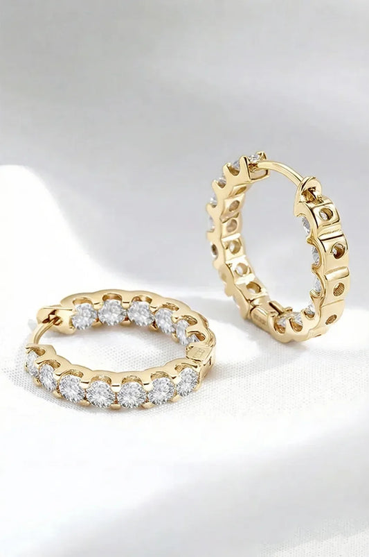 Luxury gold moissanite hoops displayed on white texture.