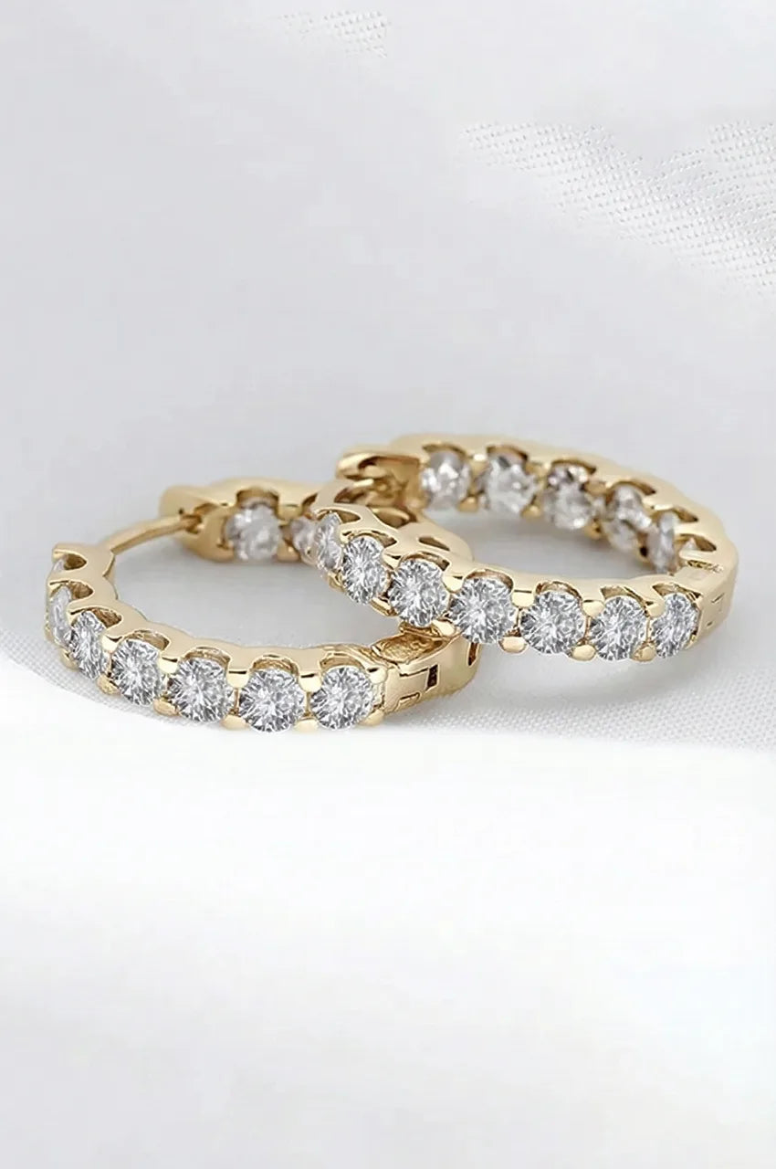 Detailed macro shot of gold vermeil hoop earrings showing the hinge closure and stone brilliance.