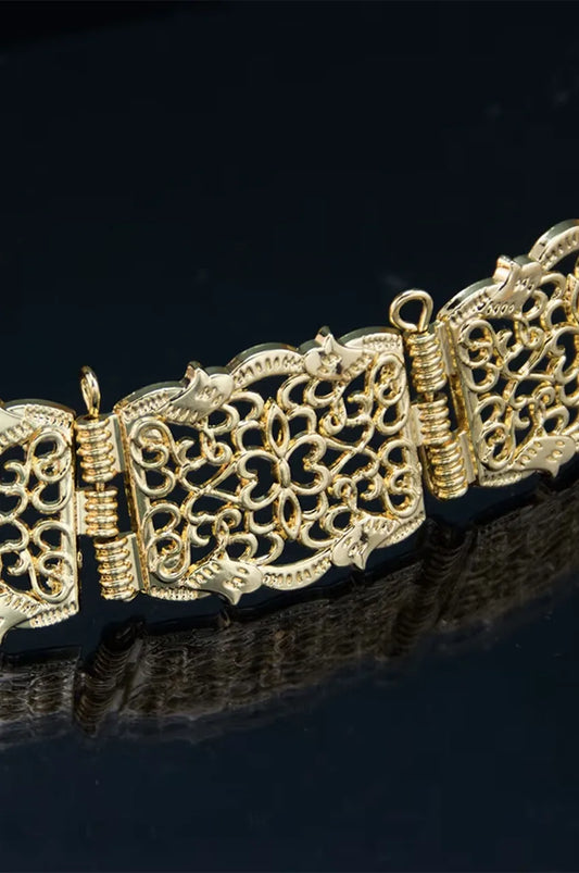 Macro shot of the intricate floral openwork design on the gold square metal belt plates.