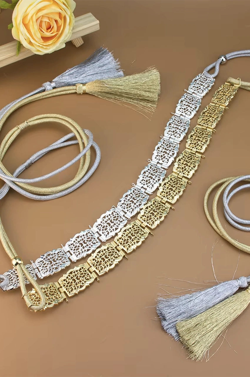 Overhead comparison of Naylara's Gold and Silver Square Filigree Metal Belts featuring intricate floral cutouts and matching adjustable braided rope tassels.