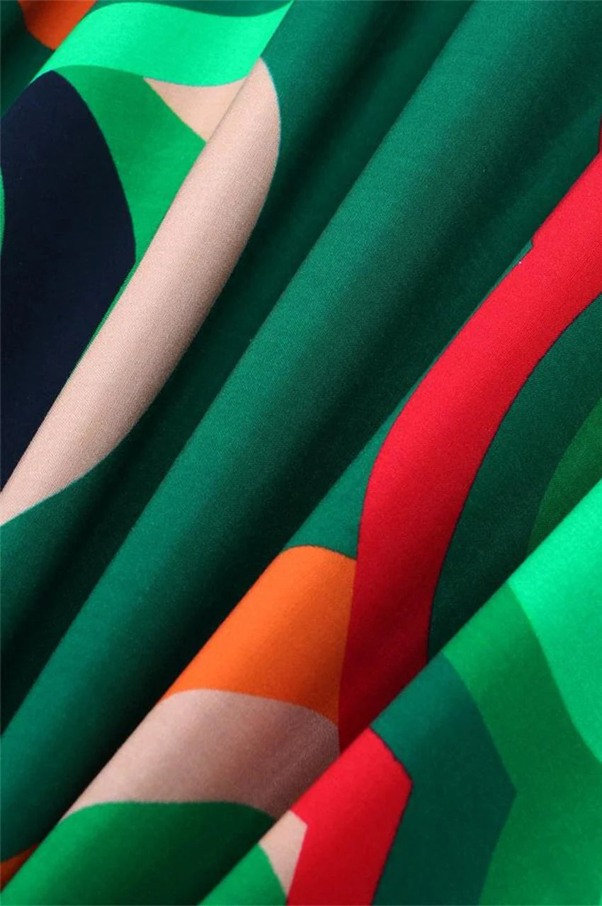 Close up of green kaftan fabric showing colorful abstract print texture