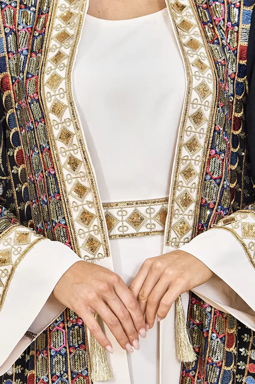 Close-up of gold sequins and multi-colored geometric embroidery on the black plus size sequin kaftan.