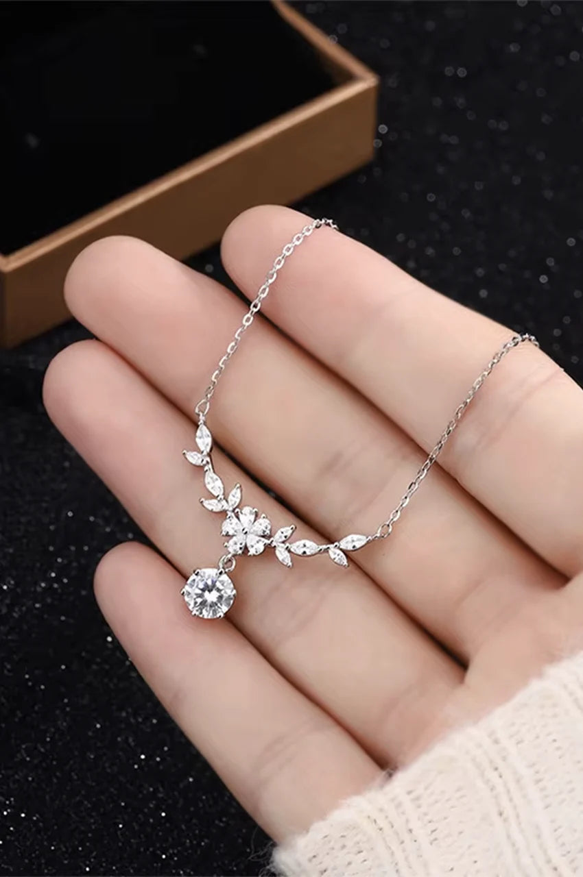 Hand holding silver bridal necklace to show scale, shine, and flexibility