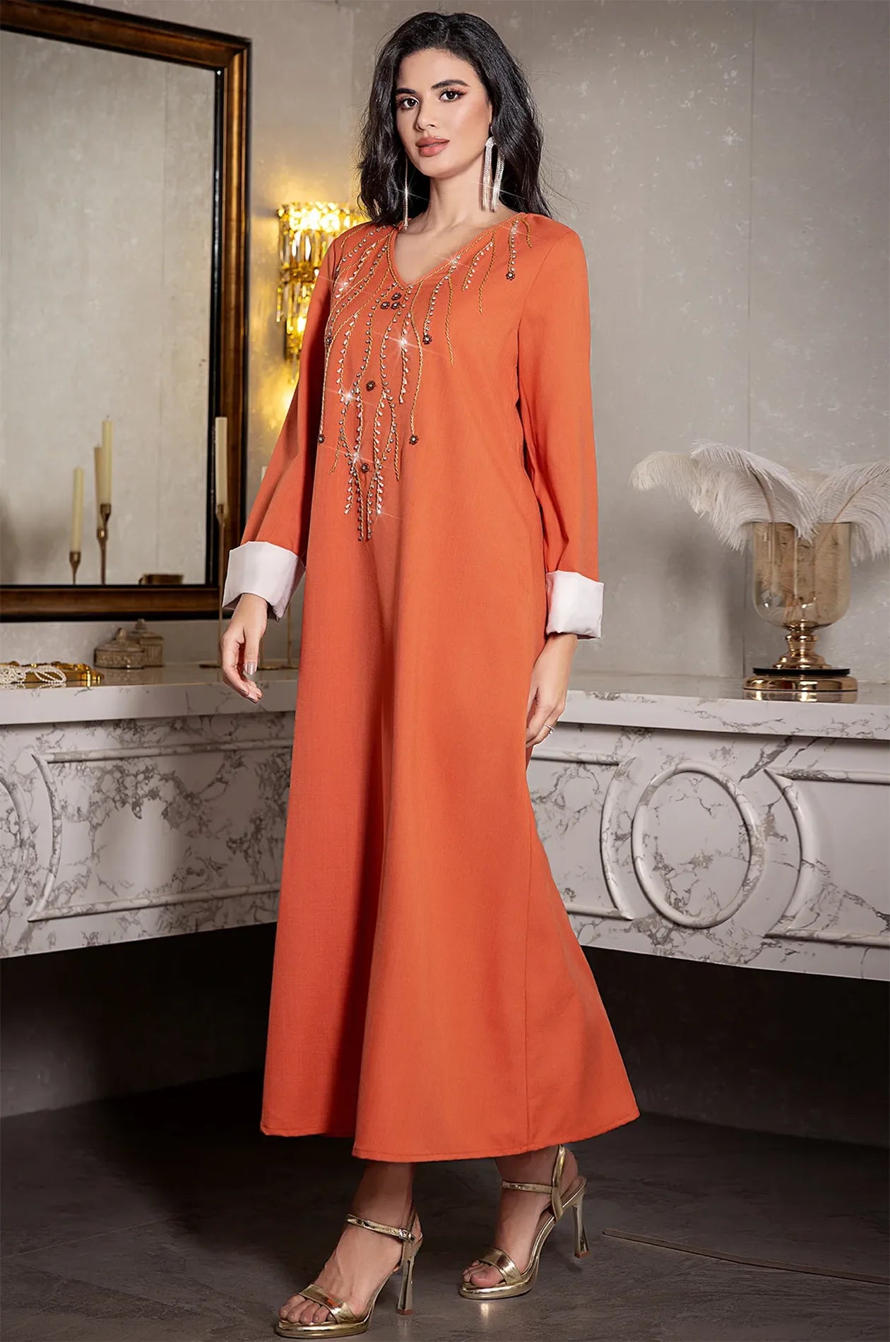 Full body shot of the Ilena embellished kaftan paired with gold high heels.