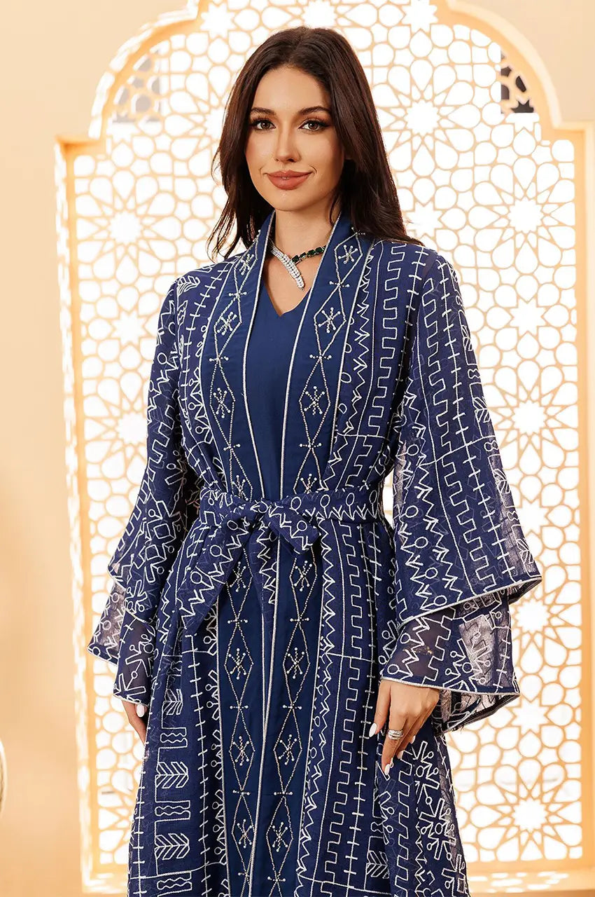 Close-up of the geometric white embroidery on the neckline of the Ilyah midnight blue sheer kaftan.