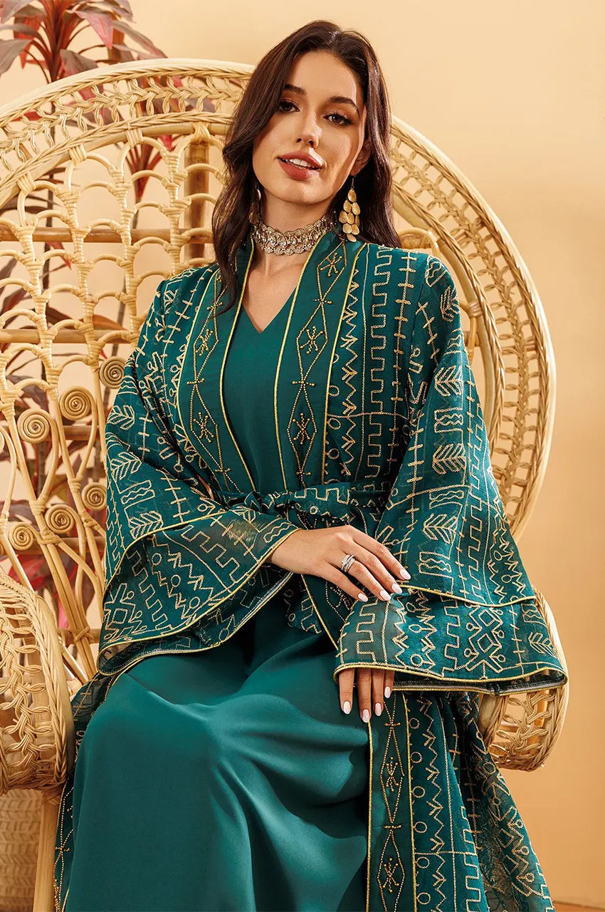 Seated view of the emerald green embroidered belted kaftan dress with gold geometric detailing.