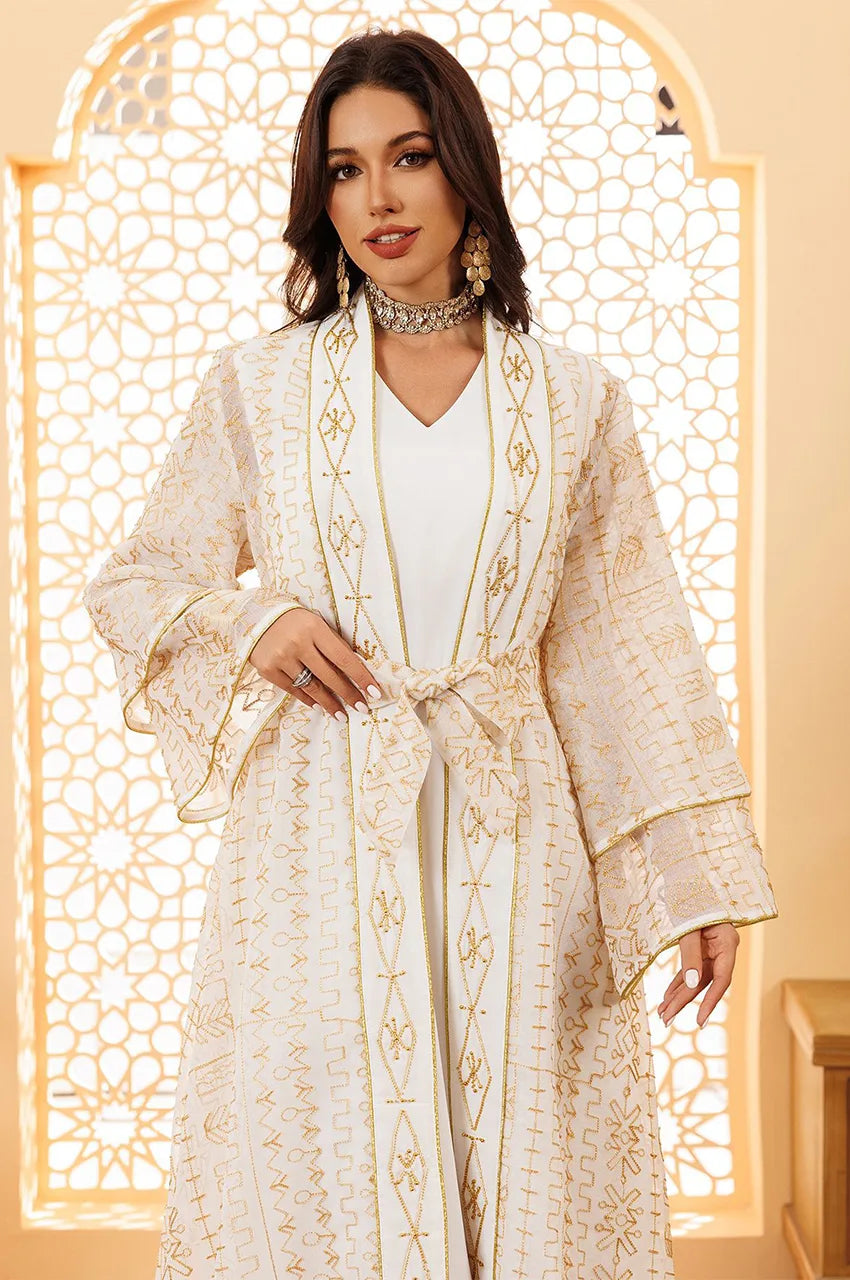 Close-up detail of the gold geometric embroidery on the sheer overlay of the Ilyah white bridal kaftan.