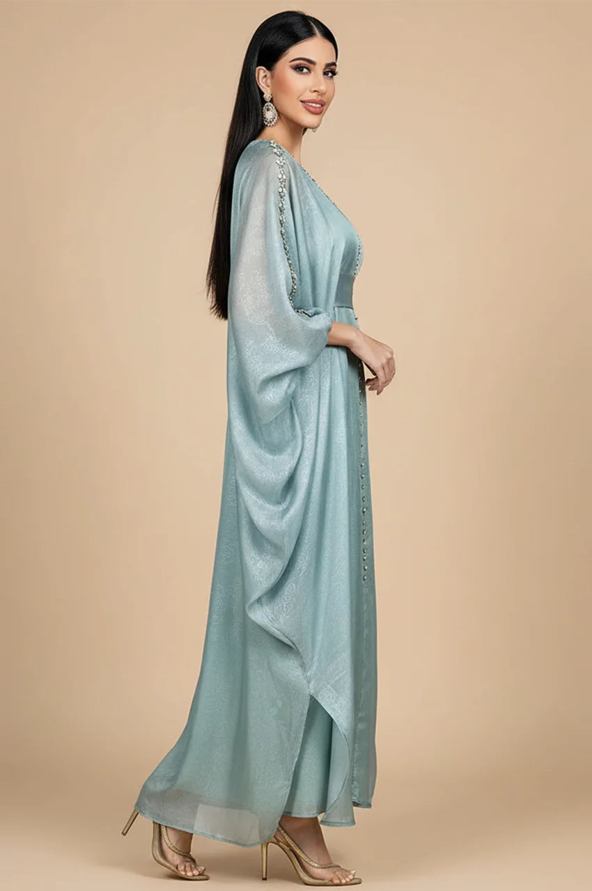Side profile of woman wearing light blue Jalya kaftan showing sleeve drape