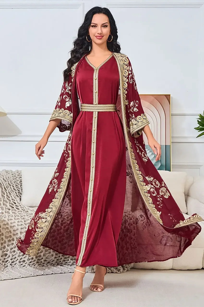 Model walking in Kalima red and gold open kaftan showing fabric flow.