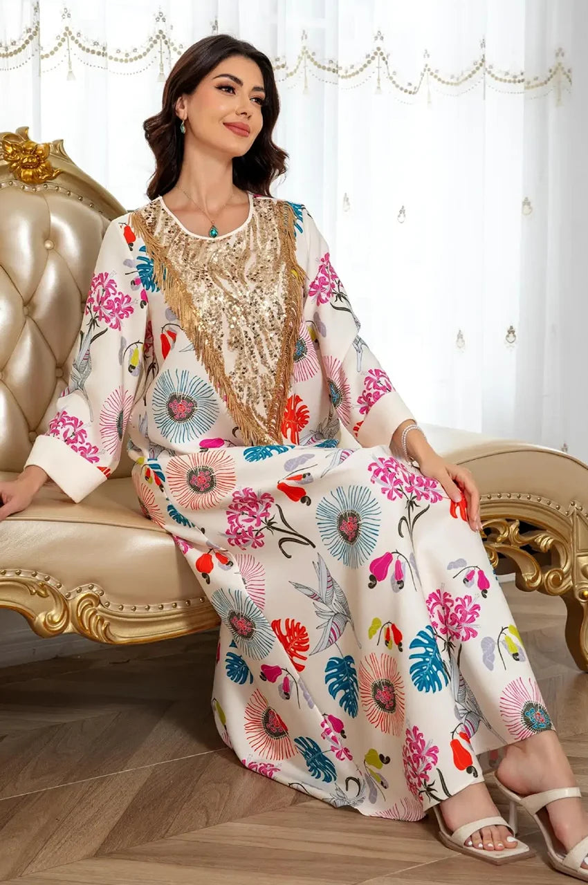 Seated view of cream floral Kashmiri kaftan with embellished gold neckline