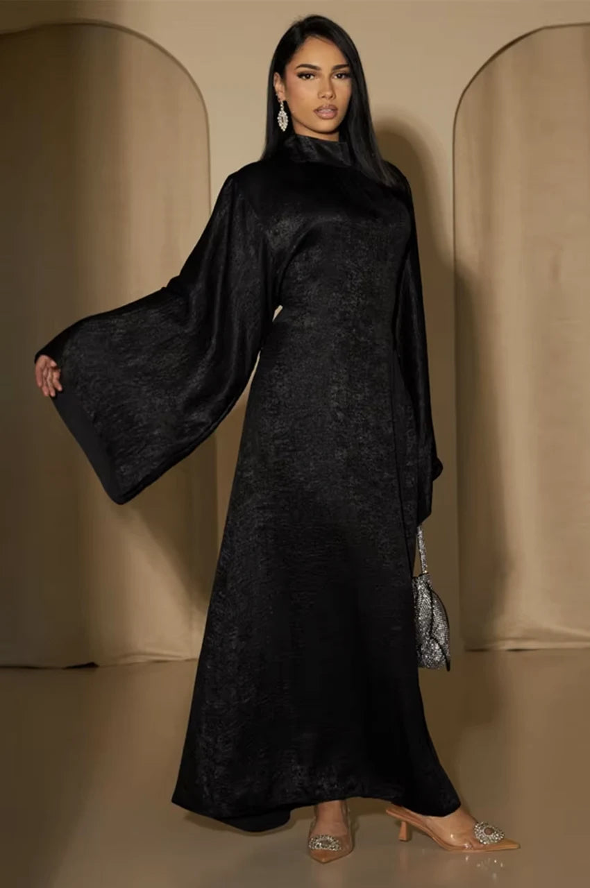 Side pose of Kehlia metallic black kaftan showing wide draped sleeves and shimmering texture