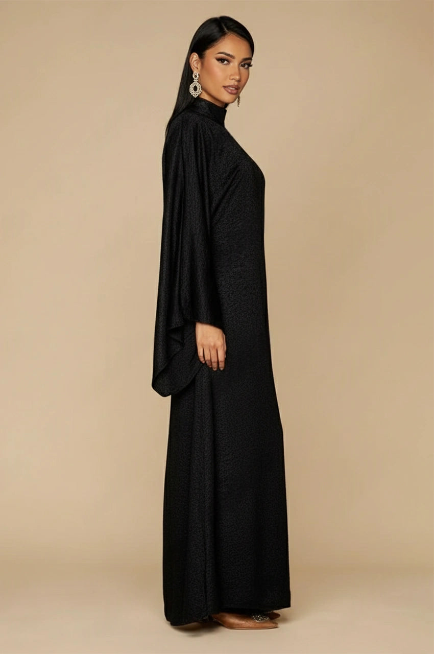Side view of Kehlia metallic black kaftan featuring elegant draped sleeves and high neck design