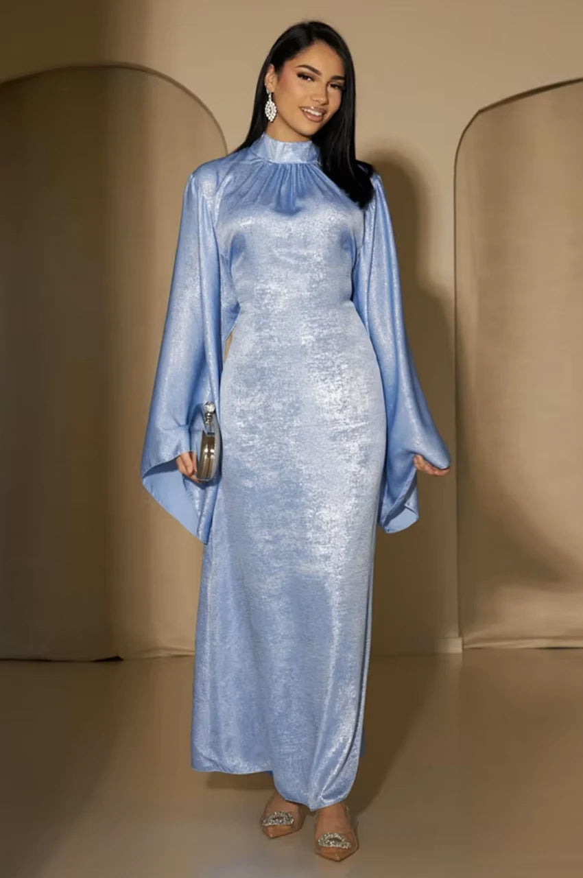 Model smiling in Kehlia metallic light blue kaftan with wide sleeves and high neckline