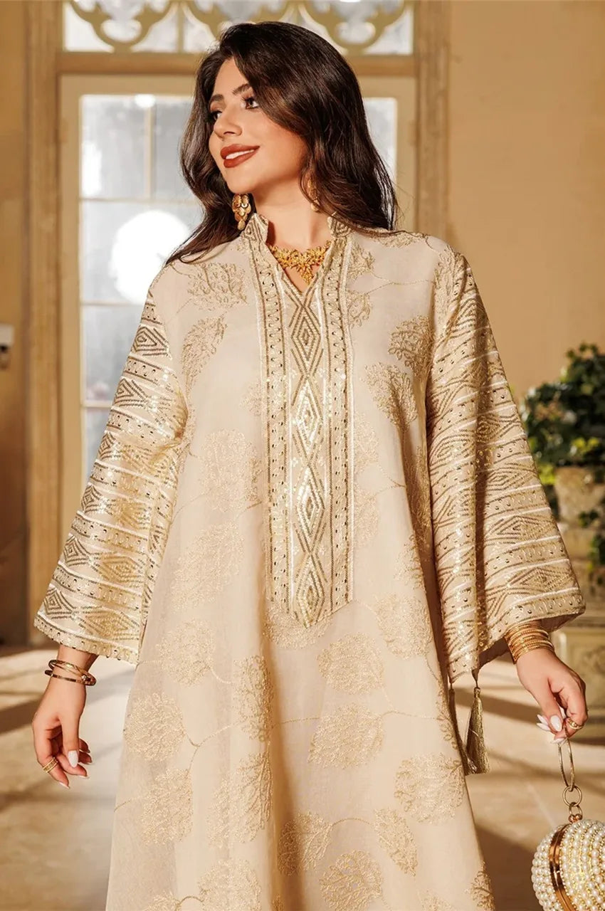 Close-up of beige Leena Persian kaftan with gold embroidery and tassels