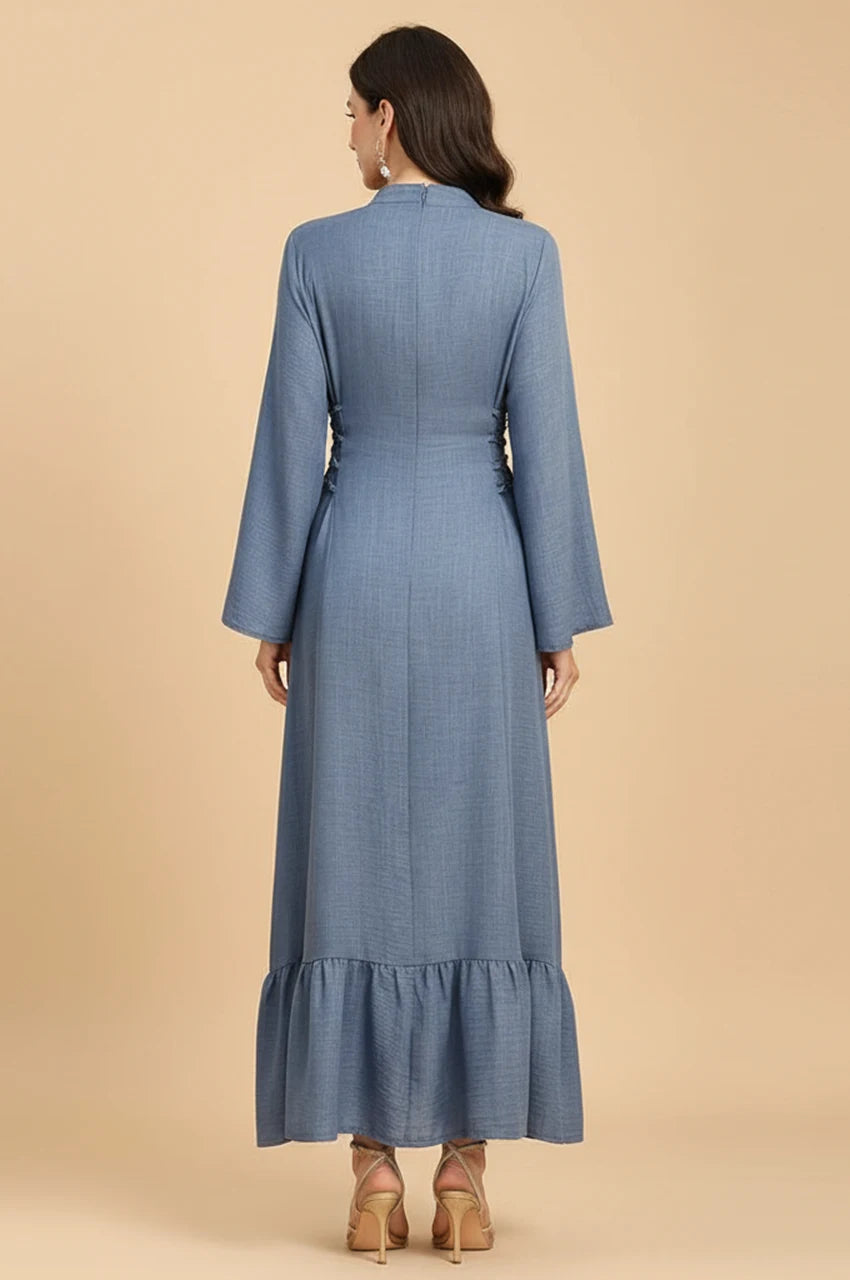 Back view of Lumis light blue kaftan showing the adjustable side-tie corset detailing and ruffled hem.